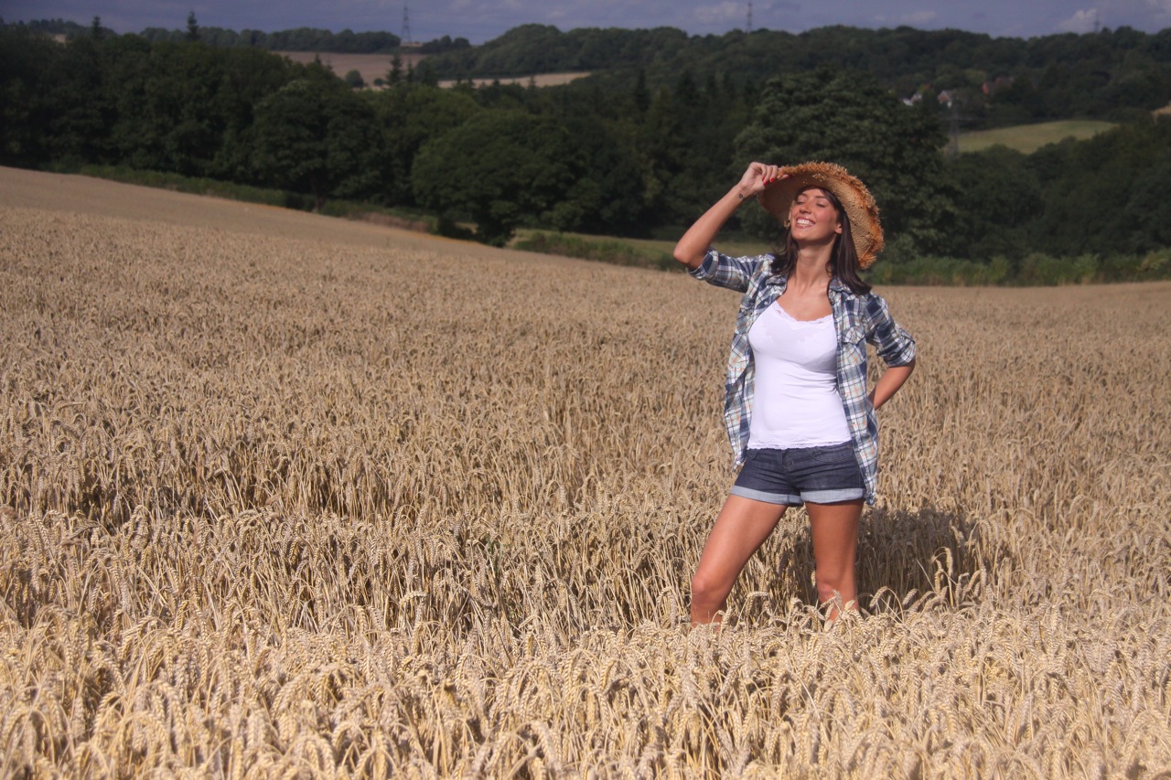 Young female model standing in cornfield